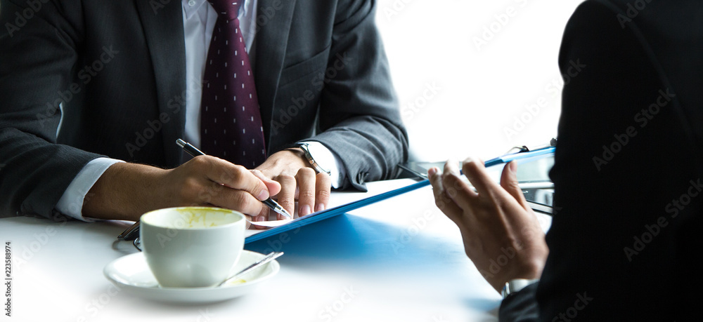 Fototapeta premium Businessmen and business women are meeting and using a tablet.