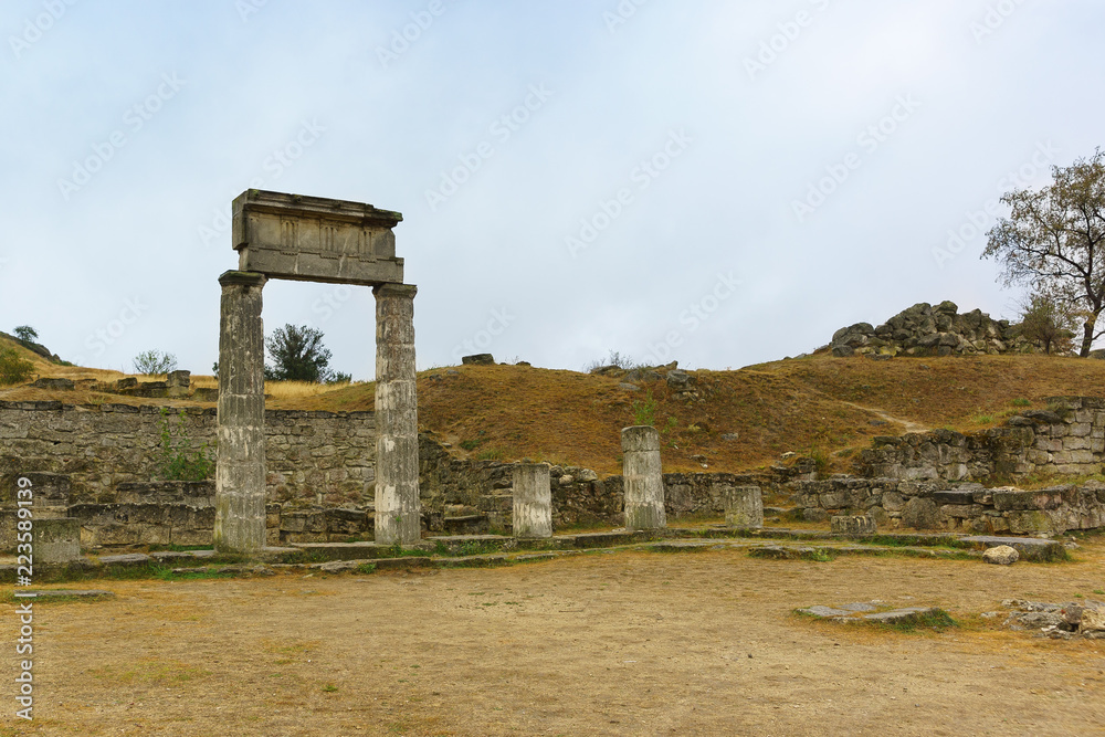 Ancient arch with carved stone portico-the ruins of the ancient Greek city of Panticapaeum on mount Mithridates in Kerch on a cloudy autumn day