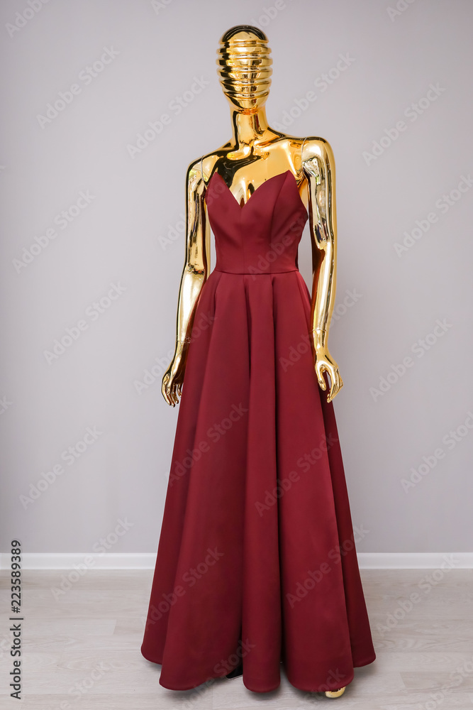 Burgundy dress on gold mannequin