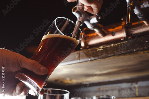 bartender pours a dark beer close up