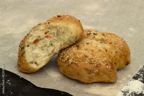 Bun with sesame and carrots on baking paper