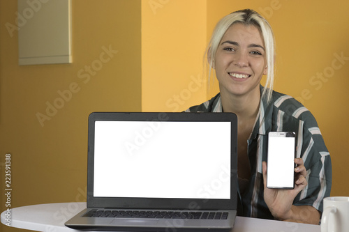 Office worker showing a mockup on laptop and mobile
