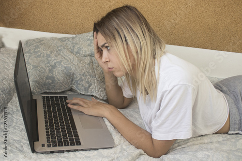 pretty young girl with computer in bed photo