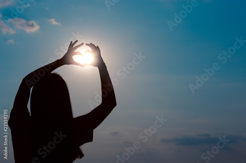 Woman Making Heart Sign Gesture in Sunset Sunlight