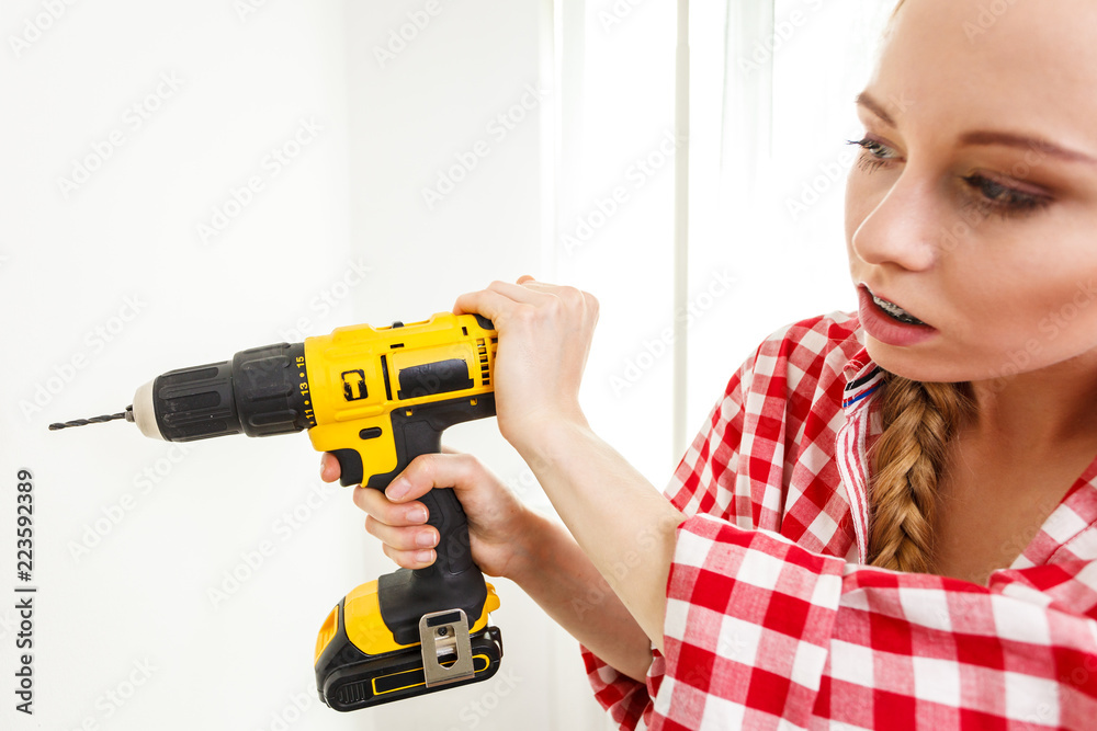 Woman having troubles using drill Woman having troubles using drill