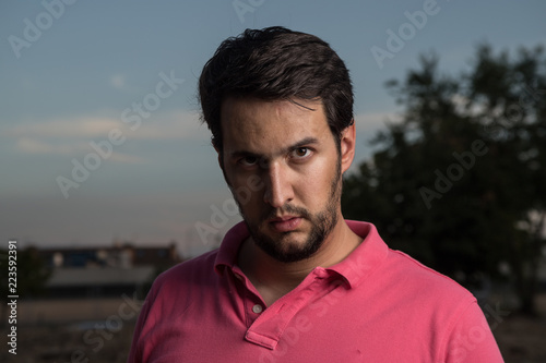 young man with intense look and beard, staring