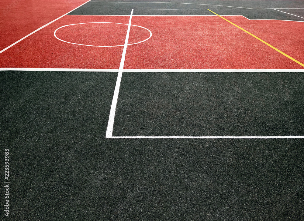 Surface of red and black sports field with white lines. Playing ground for games