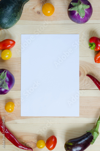 Vertical white sheet among the vegetables on the wooden background. 