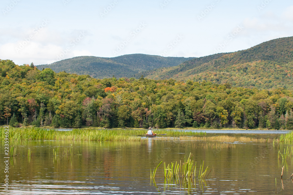 Female in a canoe on an Adirondack lake in early autumn.