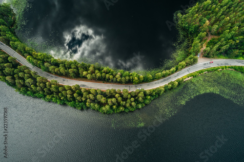 Road on a narrow piece of land between two lakes with forest photo
