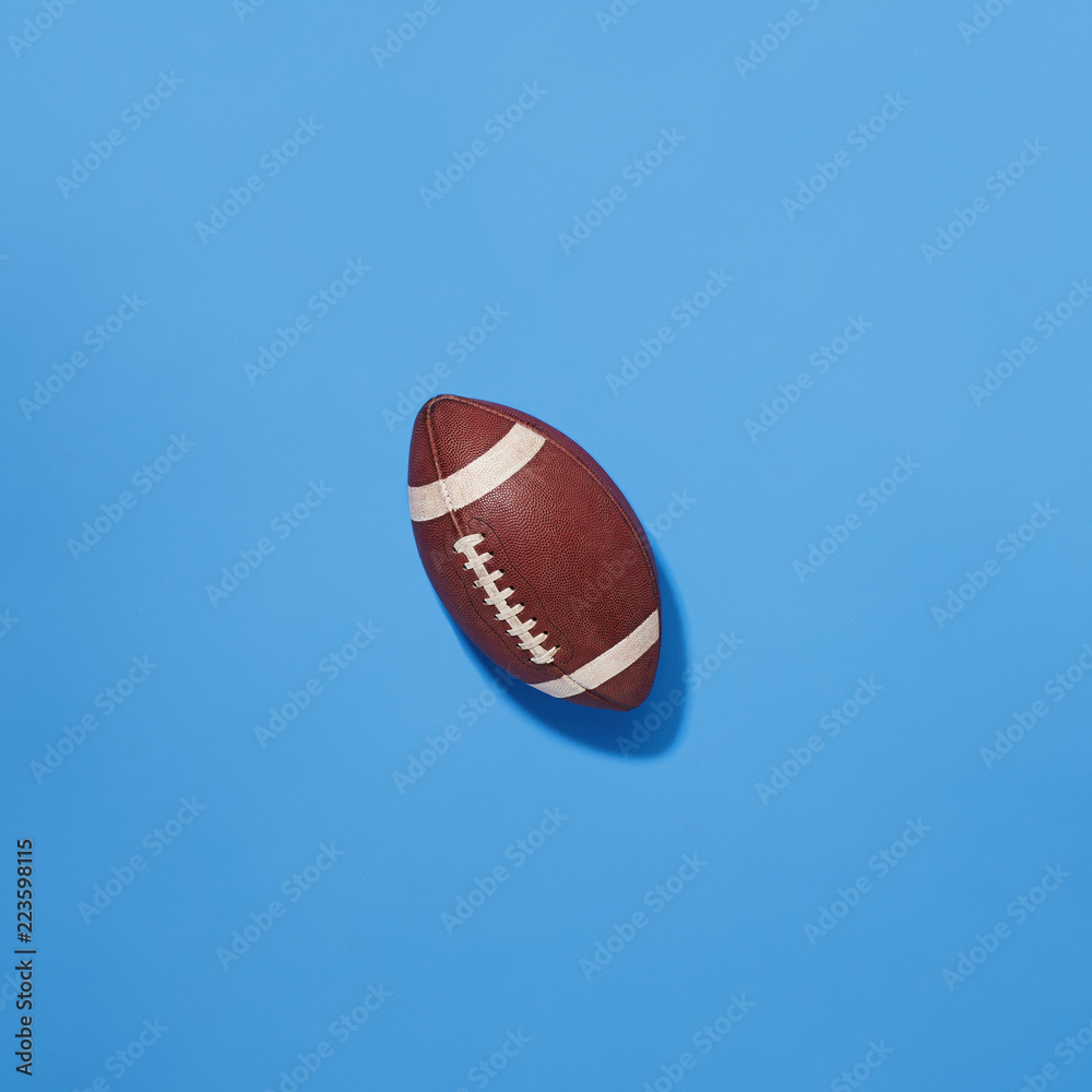 Classic NFL Football Leather Pigskin Worn Football Top Down View on Blue Background Classic NFL Football Leather Pigskin Worn Football Top Down View on Blue Background