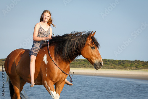 Reiterin mit Pferd am Strand