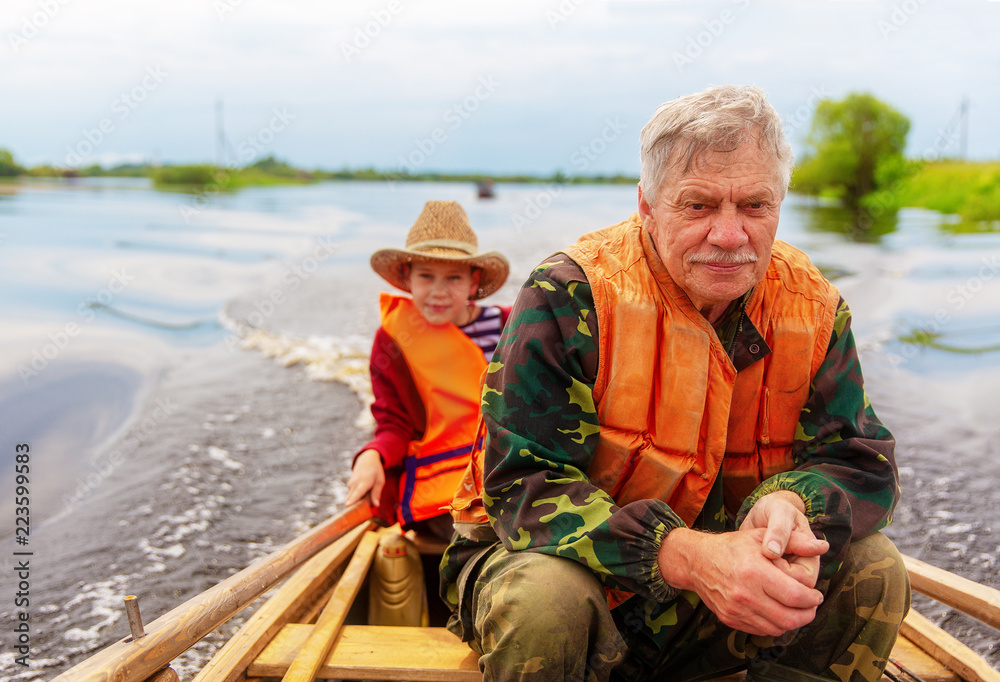 Fototapeta premium grandfather with his grandson on a fishing trip. Copy space for your text