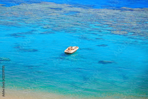 beach with coral reef, turquoise sea and boat