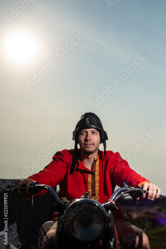 Russian motorcyclist on old Soviet motorcycle on sky background