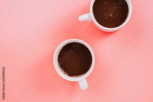 Flatlay of two cup vegan cocoa or hot chocolate on pink