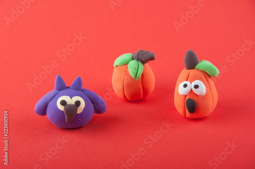 Cute purple owl and orange pumpkins stying on red background
