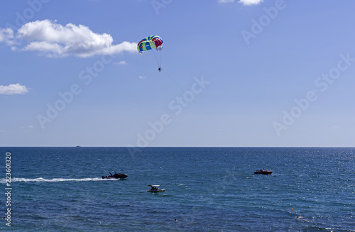 Water attraction - a boat tows a men on a parachute over the sea.