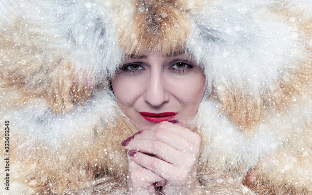Φωτογραφία Portrait of a frozen young girl in a fox fur coat, warm her hands, cold, snow, f
