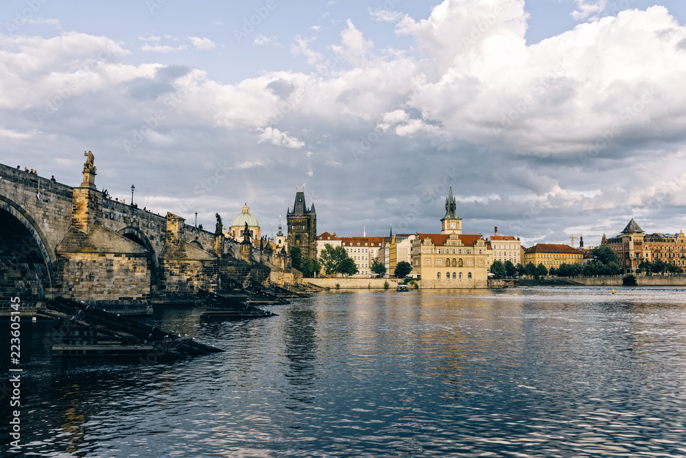 Charles Bridge over Vltava river against cloudy sky Charles Bridge over Vltava river against cloudy sky