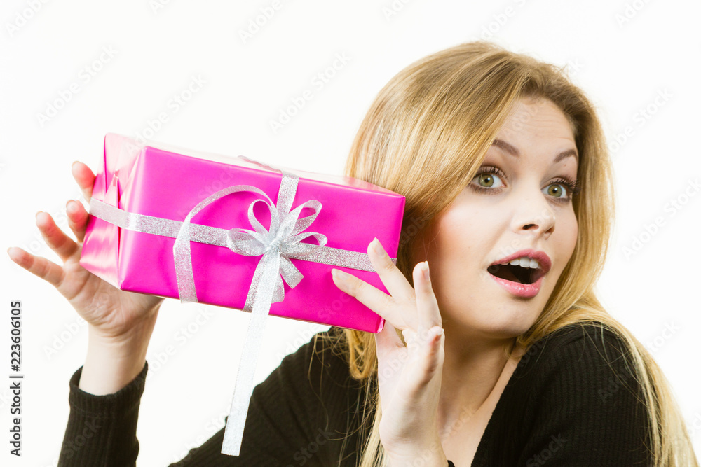 Curious woman holding gift box