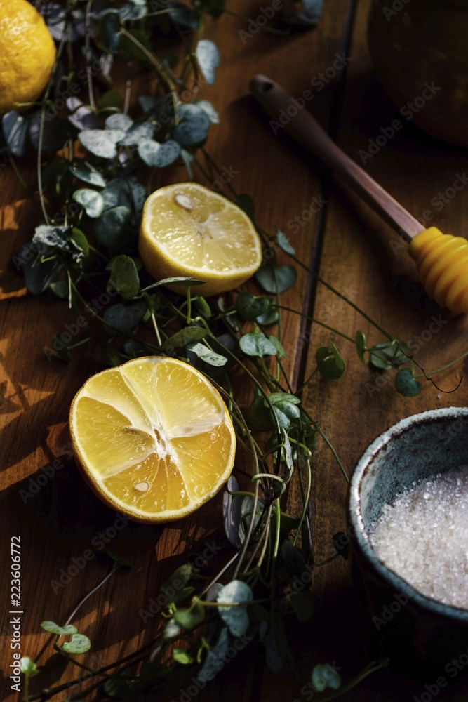 High angle view of lemon slices with sugar and plants on wooden table High angle view of lemon slices with sugar and plants on wooden table