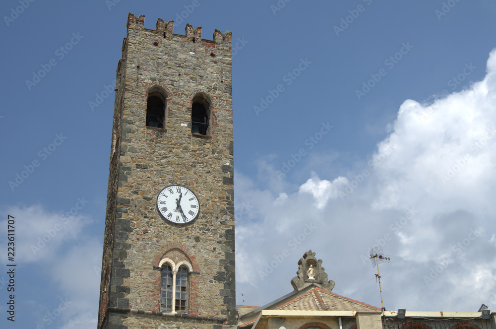 Vecchia torre con l'orologio di una piccola chiesa di un piccolo paese su una di una scogliera italiana.