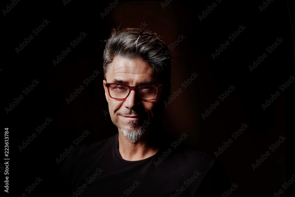Portrait of an older white guy dark background