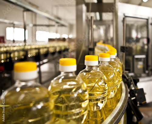 Sunflower oil in the bottle moving on production line. Shallow dof.