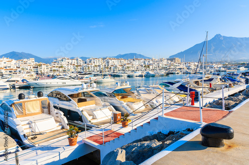 View of Puerto Banus marina with boats and white houses in Marbella town at sunrise, Andalusia, Spain © pkazmierczak