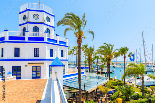 Beautiful lighthouse building and palm trees in Estepona port on Costa del Sol coast, Spain photo