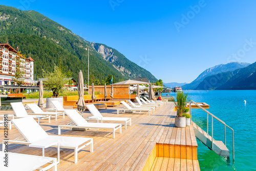 Chairs on pier in Pertisau town on sunny summer day on shore of Achensee lake, Tirol, Austria