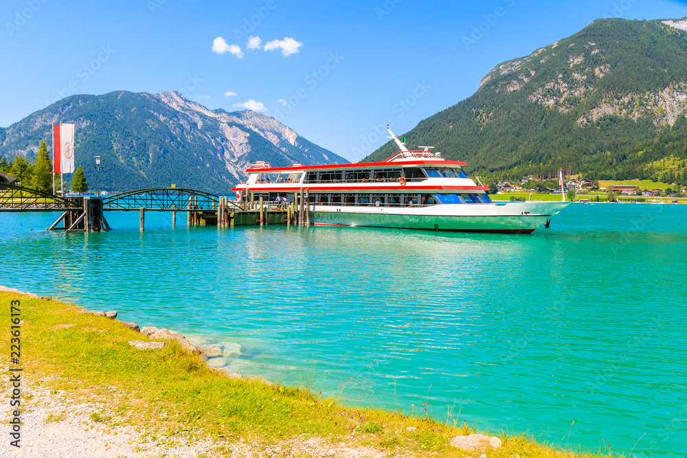 Tourist ship mooring at pier on shore of Achensee lake on sunny summer day, Tirol, Austria