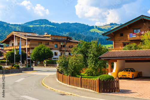 Typical alpine houses on street in Reith bei Kitzbuhel village in Alps mountains summer landscape on sunny day, Tirol, Austria