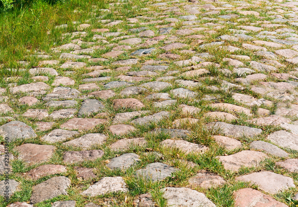 Old German paving stones. The road is paved with stone. Cobblestone sidewalk. Old German paving stones. The road is paved with stone. Cobblestone sidewalk.