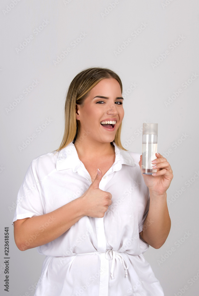 beautiful blond girl size plus model holding skin tonic micellar water in white skin dermatology concept beautiful blond girl size plus model holding skin tonic micellar water in white skin dermatology concept