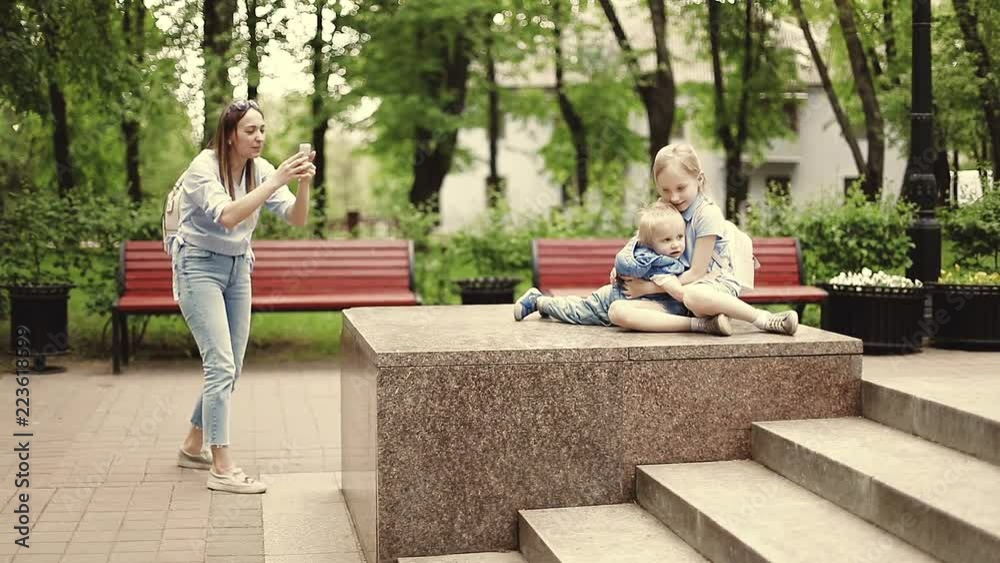 Young mother takes photo of children in the park. Young mother takes photo of children in the park.