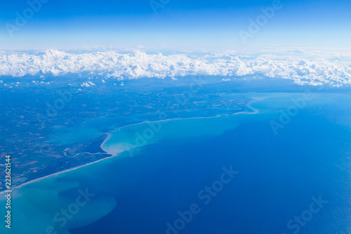 Blue planet Earth seen from high above through an airplane window. Unique panoramic high altitude aerial view of thunderstorm clouds over Venice Lagoon  Trieste Gulf seen through an airplane window.