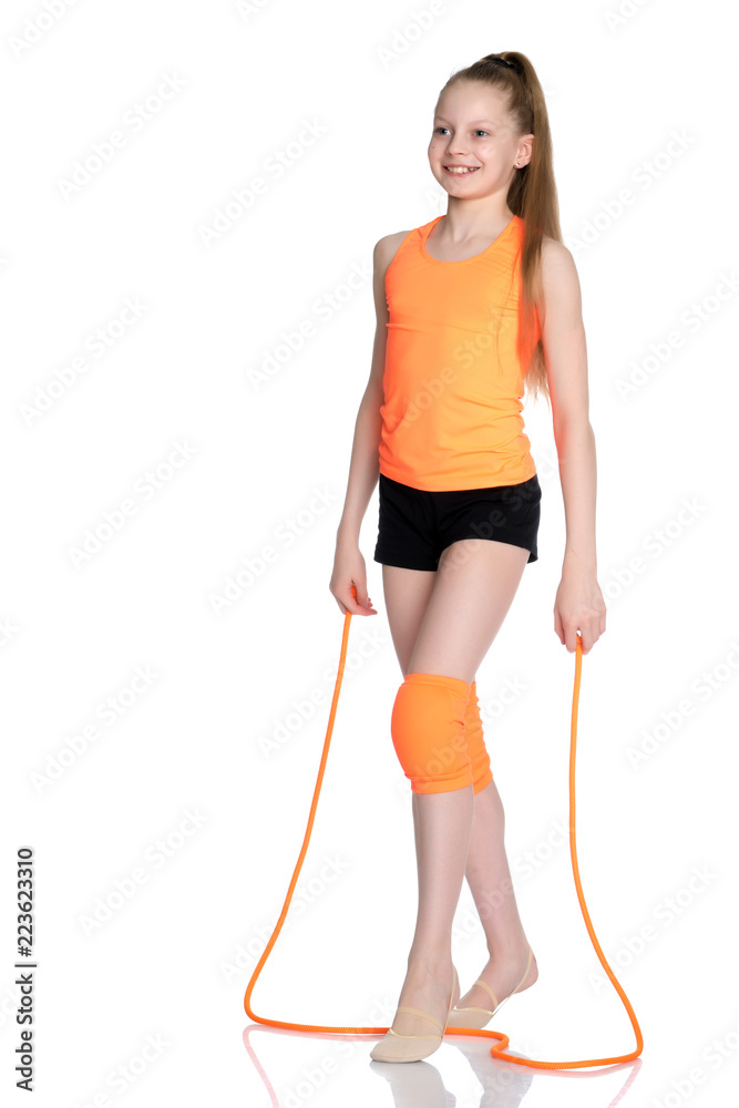 A girl gymnast performs exercises with a skipping rope.