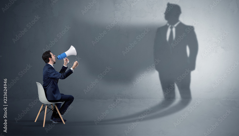 Humble businessman staying and offering stuffs to a huge businessman shadow
Humble businessman staying and offering stuffs to a huge businessman shadow