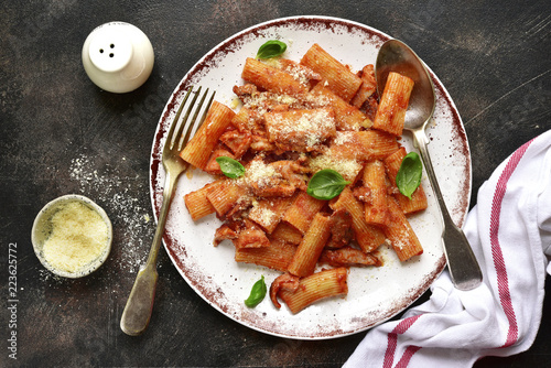 Pasta rigatoni in tomato sauce with chiken and parmesan cheese.Top view. photo