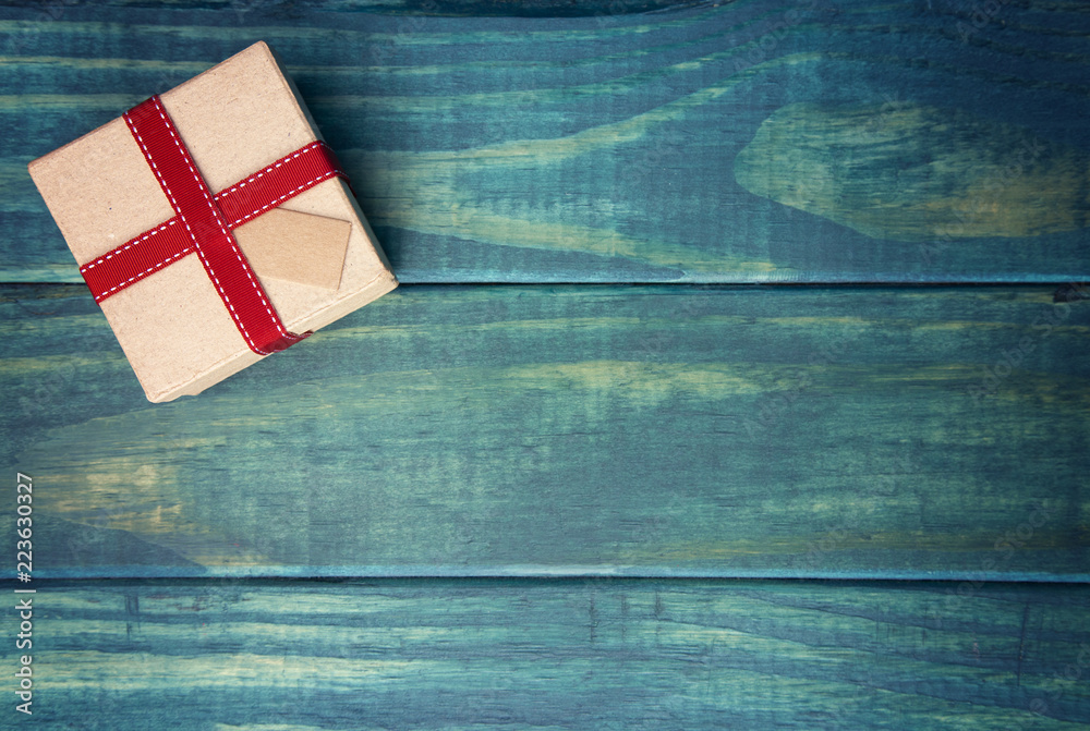 Obraz premium Single Wrapped Christmas Present with Gift Tag on a Wooden Table