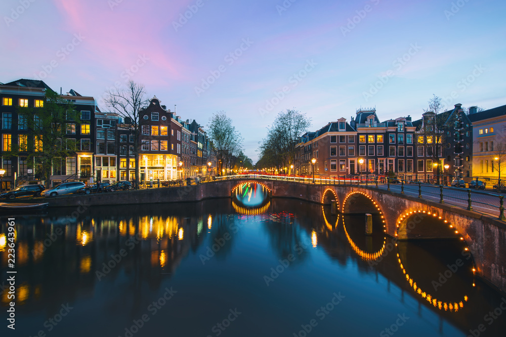Night city view in Amsterdam, Netherlands. Canal and typical dutch houses at night in Amsterdam, Netherlands