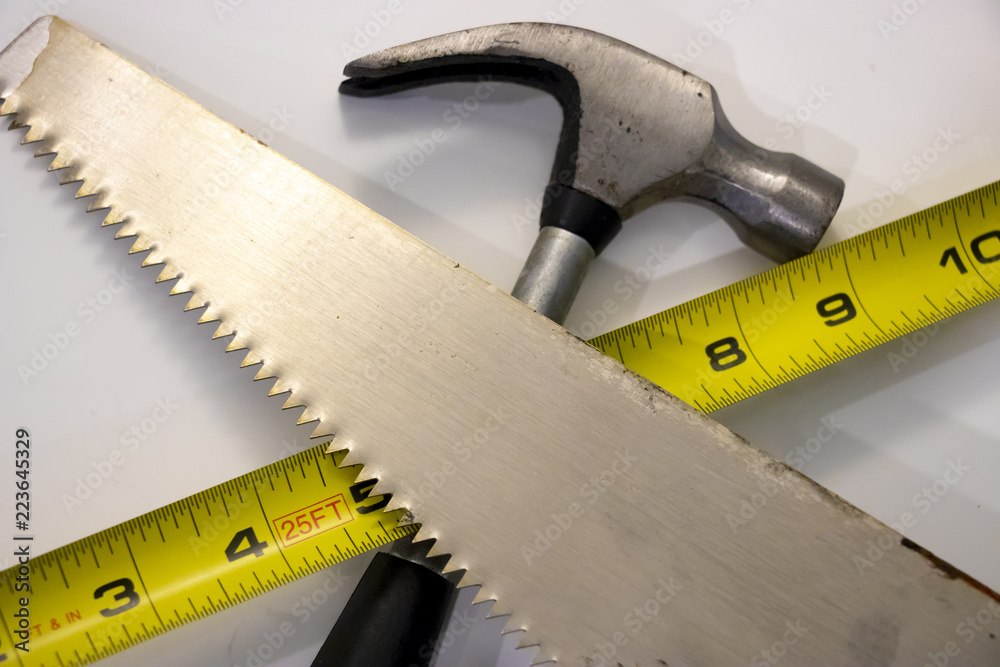 Hammer, saw and measuring tape common construction tools used for repair and wood work Hammer, saw and measuring tape common construction tools used for repair and wood work