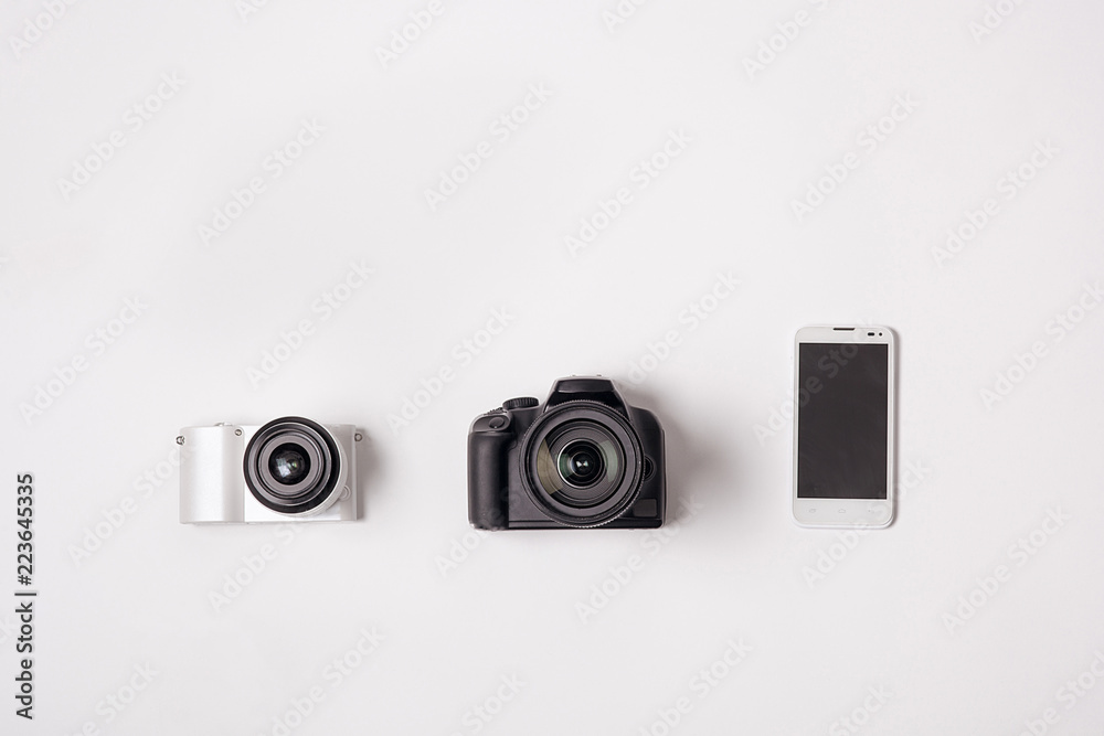 SLR camera and the smartphone was lying on a white background SLR camera and the smartphone was lying on a white background