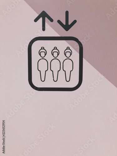 Black ELEVATOR sign on the pink tone background.