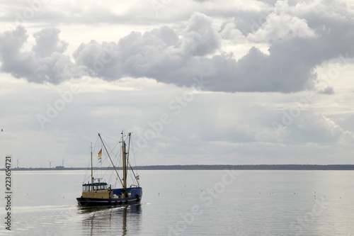 Fishing boat is emptying the nets, placed along the Aflsluitdijk in a calm peacfull IJsslemeer