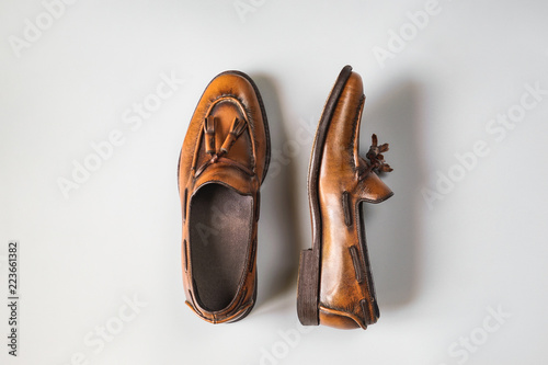 Top view of vintage brown tassel loafers on grey background