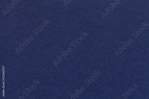 Texture of old navy blue paper closeup. Structure of a dense cardboard. The denim background.