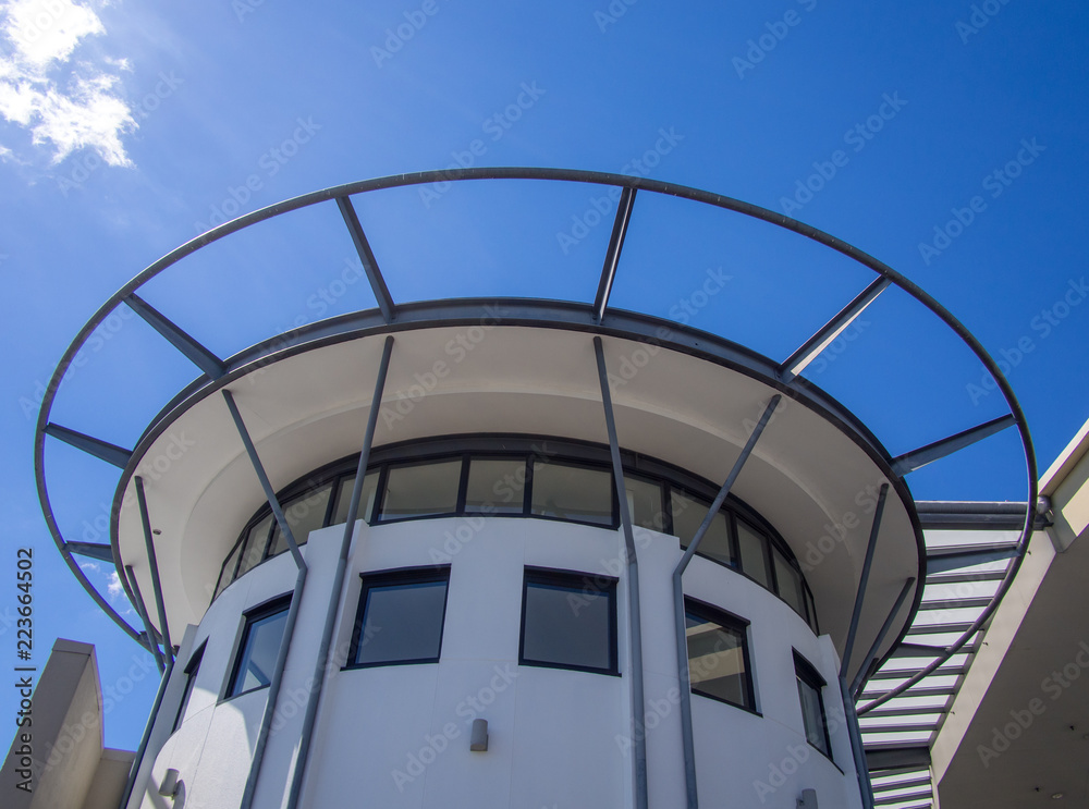 Fototapeta premium Round white top of a modern building against the blue sky